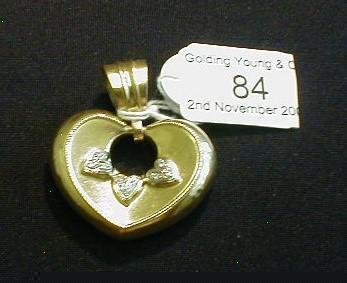 A Victorian heart pendant with three applied white metal diamond set hearts