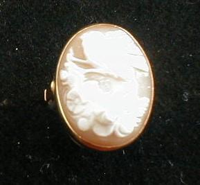 A shell cameo ring, showing a bird above flowers, set in yellow metal