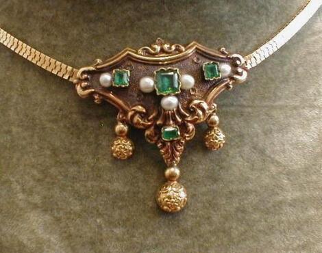 A Victorian pendant, triangular shape, set with emerald cut green stones