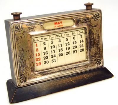 A George V silver and ebonised desk calendar