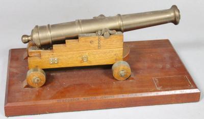 A 20thC brass table top model of a cannon