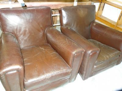 A pair of brown leather low club armchairs