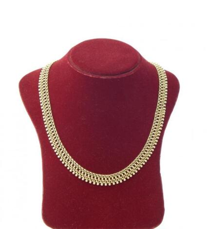 A yellow metal bead and chain link collar necklace