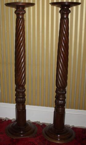 A pair of mahogany torcheres