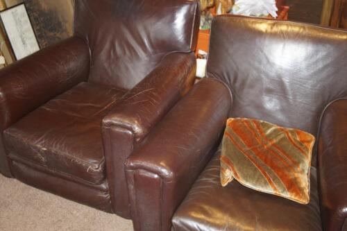 A pair of brown leather low club armchairs