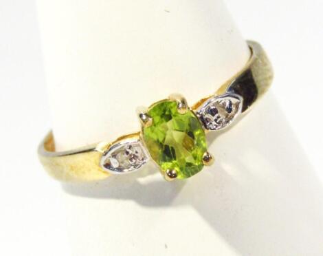 A ladies dress ring set with peridot and diamonds to the part pierced shank