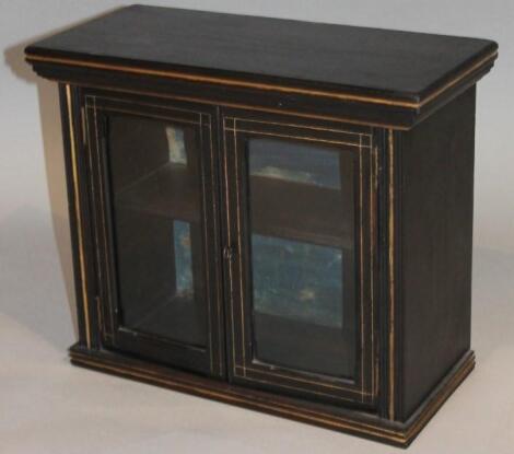 An Edwardian ebonised hanging cupboard