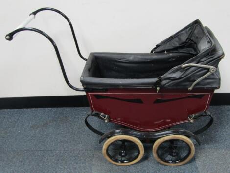 A Leeway baby carriage in red on a black chassis and black hood