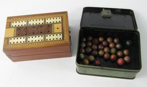 A safe form cash tin containing vintage marbles