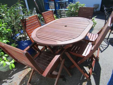 A hardwood slatted oval garden table