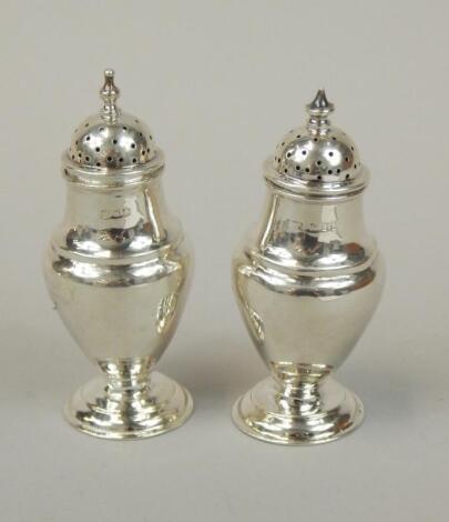 Two similar George VI silver baluster shaped pepper pots