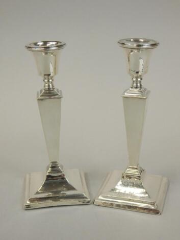 A pair of George V silver candlesticks