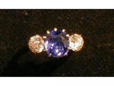 A three stone ring, a central sapphire (probably Verneuil) flanked by two diamonds 0