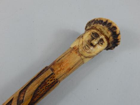 A heavily carved poker work tribal style staff