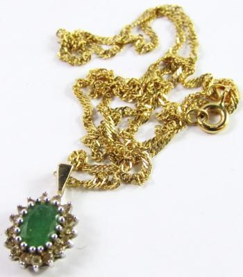 An emerald and diamond oval cluster pendant