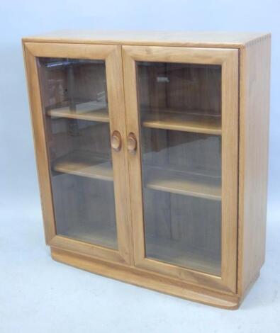 An Ercol light elm display cabinet