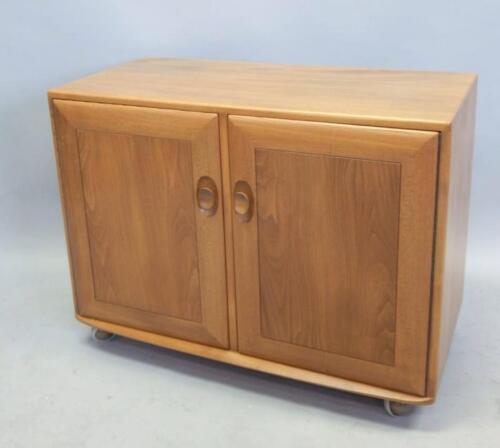 An Ercol light elm low cupboard