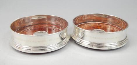 A modern pair of silver wine coasters