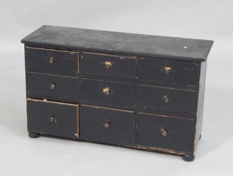 A bank of six Victorian black painted pine drawers