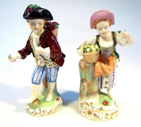 A Dresden porcelain figure of a child aside basket on a post