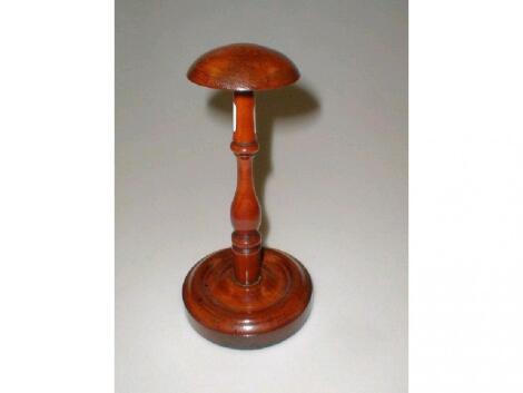 A treen wig stand, with a baluster turned stem and on a circular