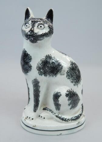 An unusual 19thC Staffordshire black and white model of a seated cat