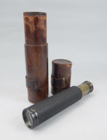 A brass 2 draw telescope, of cylindrical articulated outline, in brown leather case, (when closed) 25cm wide.