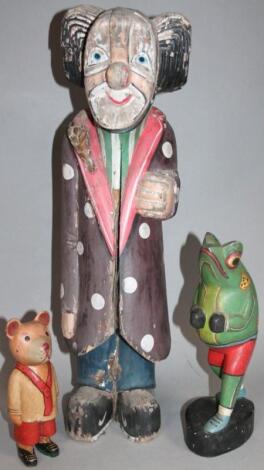 A carved wooden figure of a standing clown