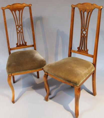 A pair of Edwardian walnut stained Chippendale design dining chairs