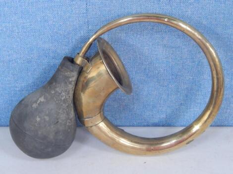 A circular brass fluted horn with rubber bulb.