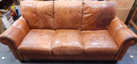 A tan leather three seater sofa