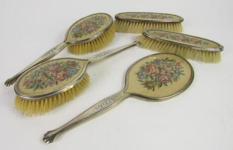 A George VI silver and embroidered floral five piece dressing table set