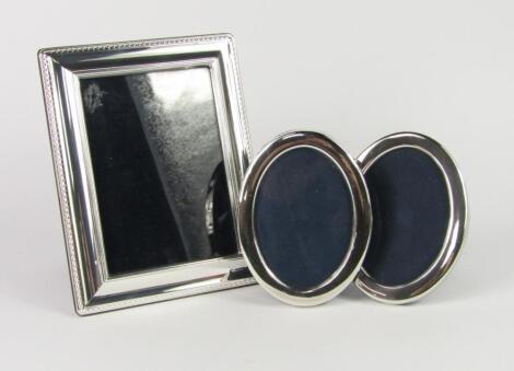 A pair of oval strut photograph frames