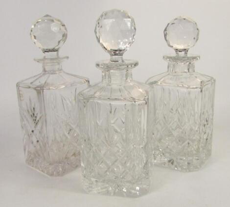 A pair of square cut glass whisky decanters and stoppers