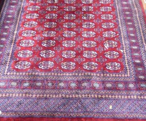 A Shiraz red ground rug decorated with floral medallions