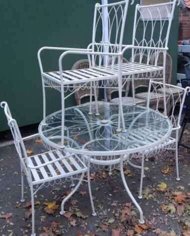 A cream painted circular cast iron garden table