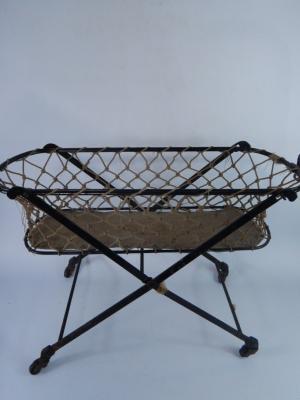 A cast iron and canvas doll's cot