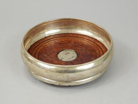 A modern silver and mahogany wine coaster