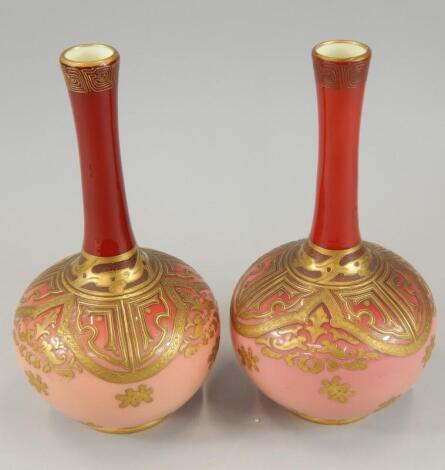 A pair of Victorian pink and red tinted opaque bottle shaped glass vases