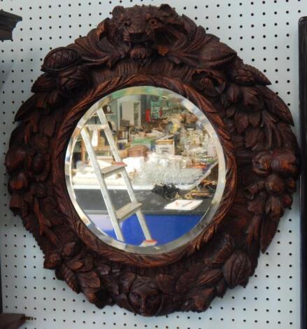 A Black Forest type carved wall mirror