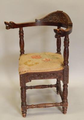 A late 19thC carved stained pine corner chair
