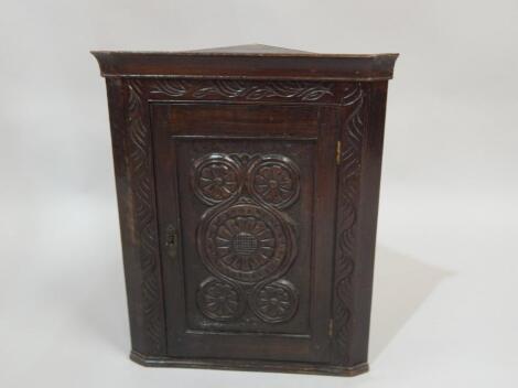 An early 20thC dark oak small hanging corner cabinet