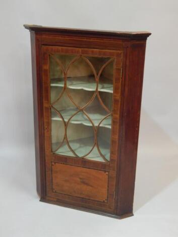 An early 19thC mahogany and boxwood strung corner cabinet