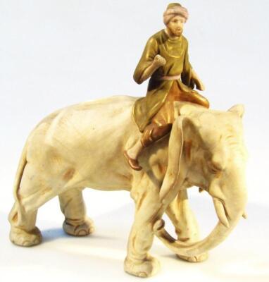 A 19thC bisque porcelain figure of a gentleman riding an elephant