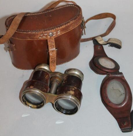 A pair of brown leather flying goggles and field binoculars