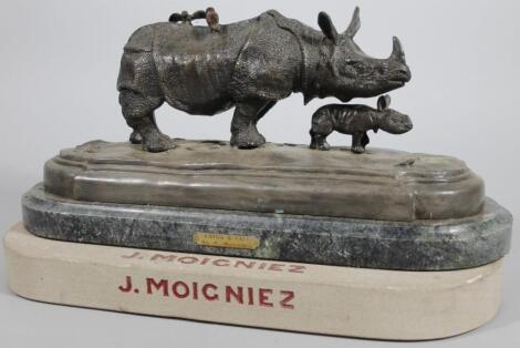 A 20thC hollow bronze figure group of two rhinoceroses