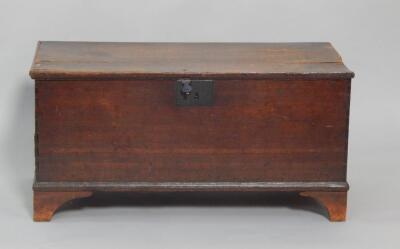 An 18thC oak coffer raised on bracket feet