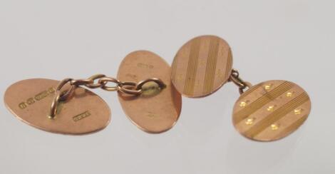 A pair of 9ct gold cuff links engraved with stripes and leaf springs