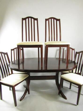 A Morris Furniture Company stained oak oval extending dining table and six single dining chairs