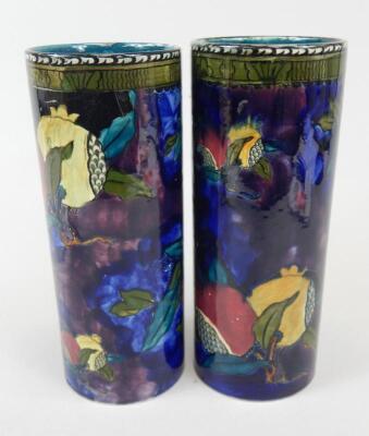 A pair of Rubens ware Pomegranate pattern cylindrical vases